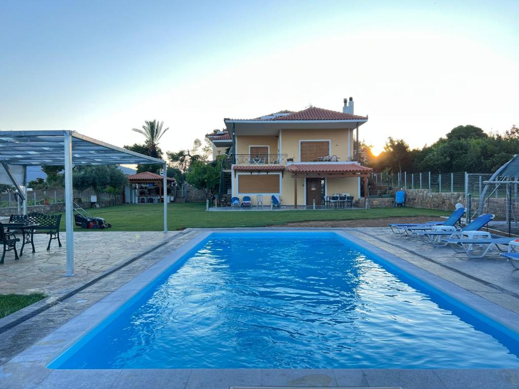 a villa with a swimming pool and a house at Athens Countryside resort with pool in Pallíni