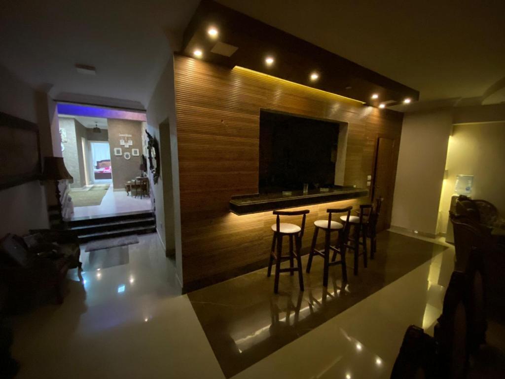 a kitchen with a bar with stools in a room at amazing apartment in the most luxurious area of ​​the Fifth Settlement in Cairo