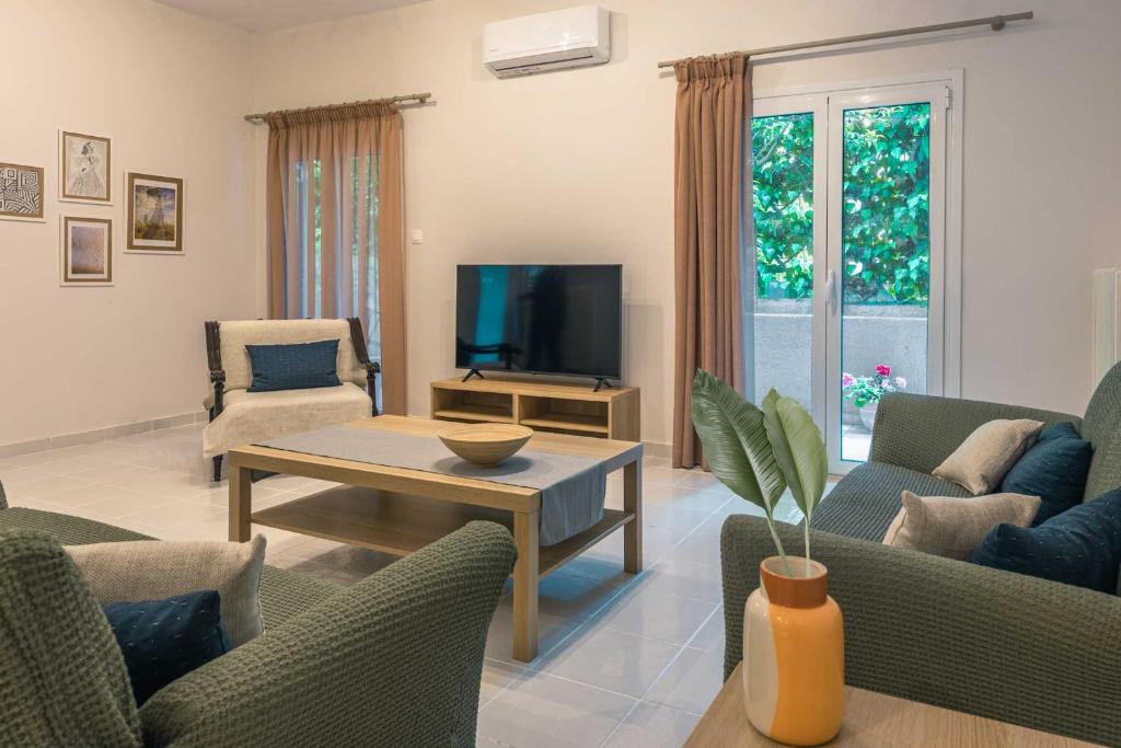 a living room with couches and a tv and a table at Coastal Getaway: Roomy Beachside Apartment! in Nea Makri