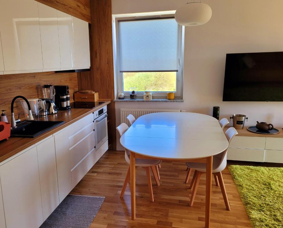 a kitchen with a table and chairs and a television at Apartament Comfort Del Mar II Kolobrzeg in Kołobrzeg