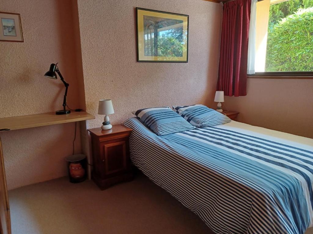 a bedroom with a bed and two lamps and a window at Calme et verdure in Buxerolles