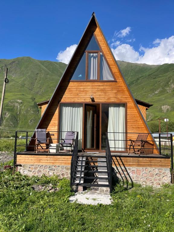 uma casa com um telhado de palha e um alpendre em Take a Break Kazbegi em Stepantsminda