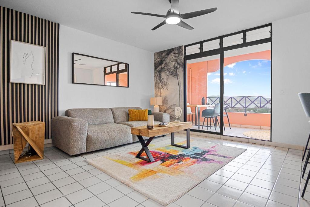 a living room with a couch and a table at Duplex standing et confort - Baby ready - 2 minutes de la plage Anse Mitan in Les Trois-Îlets