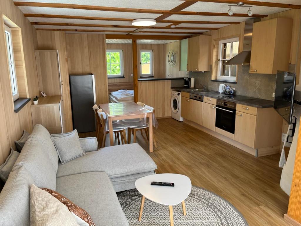 een woonkamer met een bank en een tafel en een keuken bij Tiny Haus Dornbirn in Dornbirn