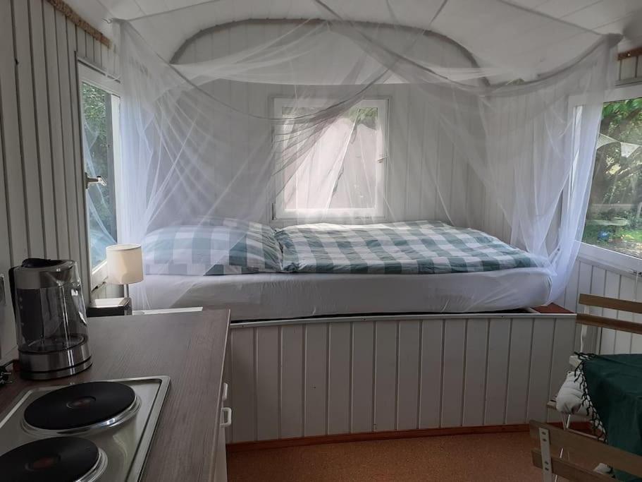 a bedroom with a bed with a white canopy at Rüdiger, der Bauwagen am Deich. 