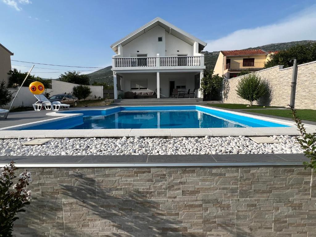a swimming pool in front of a house at Villa Zak in Blagaj