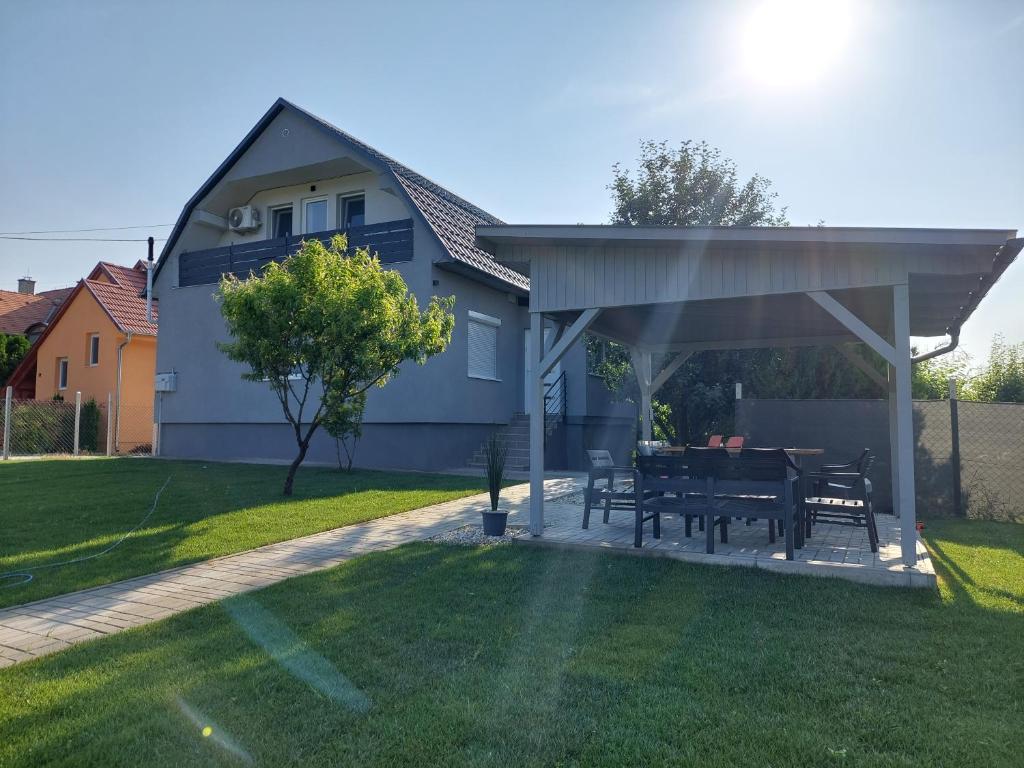 una mesa y sillas bajo un pabellón en un patio en Boutique Villa Zala, en Zalakaros