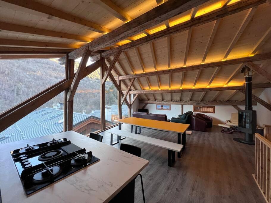 a kitchen and living room with a stove in a house at Chalet Des Legendes in La Combe