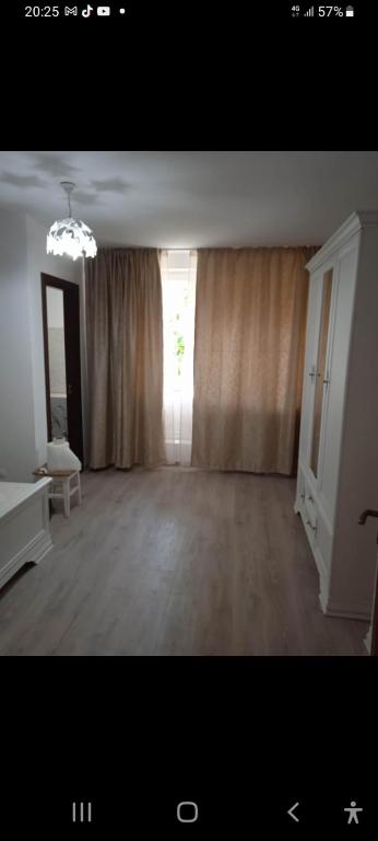 - un salon vide avec une grande fenêtre et des rideaux dans l'établissement Residence familiar Manu, à Tîrgu Neamţ