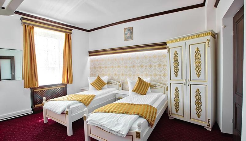 1 dormitorio con 2 camas y ventana en Pensiunea Sibiana, en Sibiu