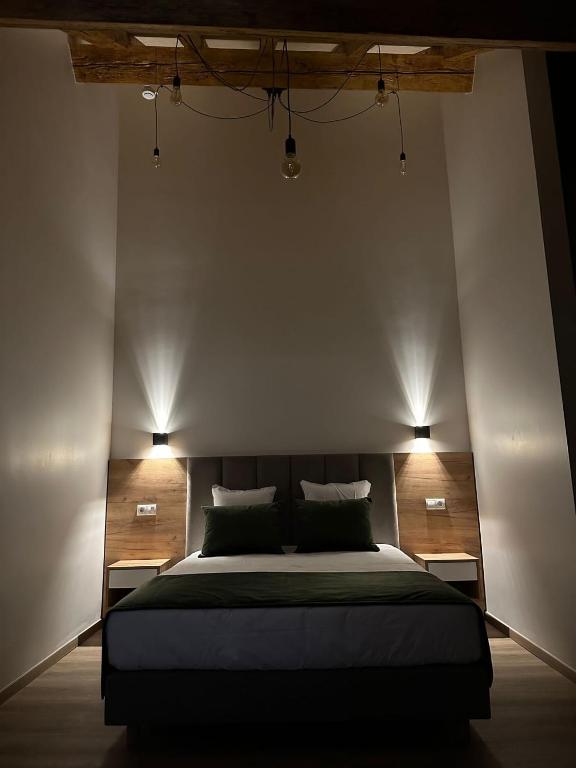 a bedroom with a large bed with two lights on it at Hotel Le Postillon in Echternach