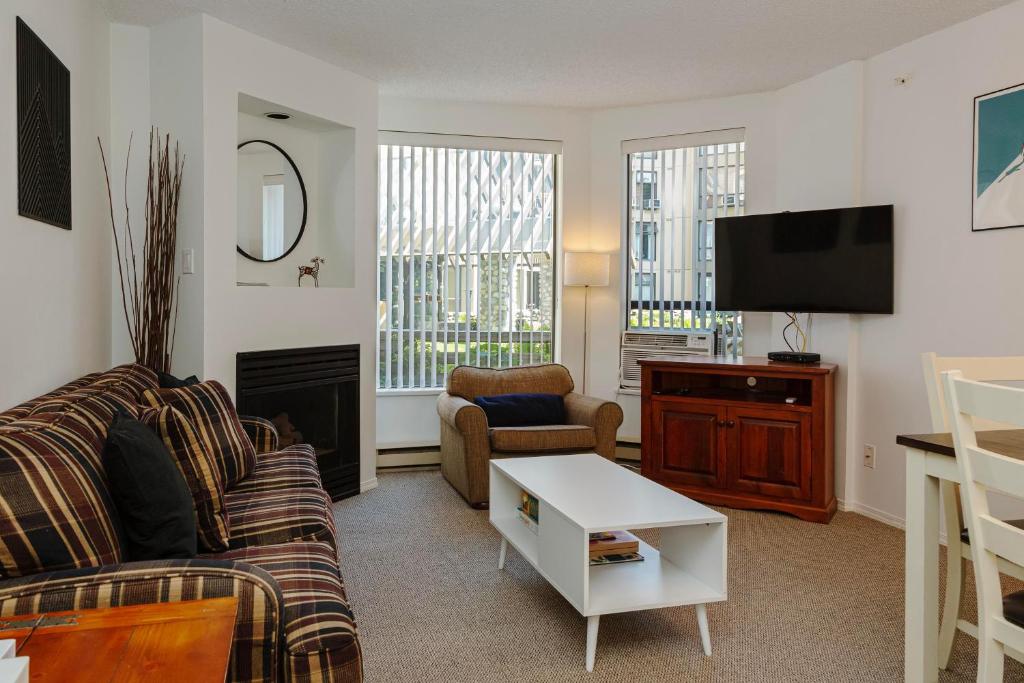 een woonkamer met een bank en een tv bij 1 bed family friendly condo on quiet Blackcomb - sleeps 5 in Whistler