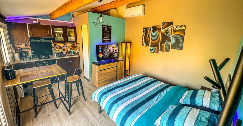 une petite chambre avec un lit et une cuisine dans l'établissement Maisonnette Jacuzzi & Piscine, à Sussargues