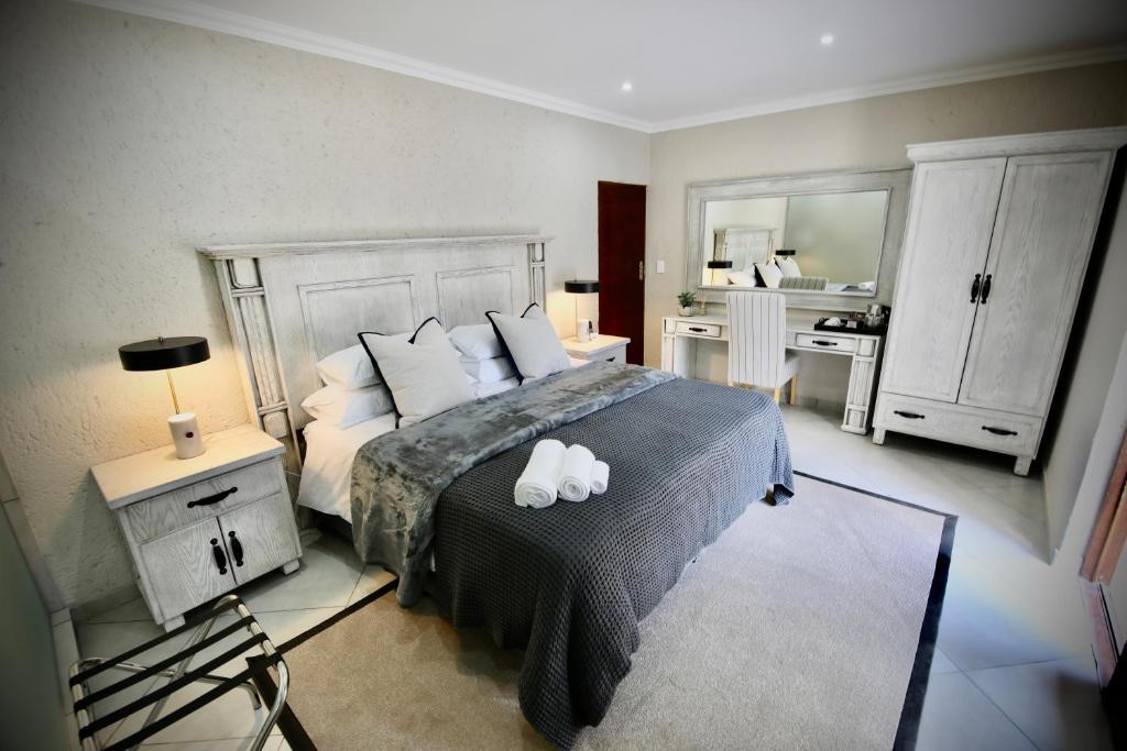 a bedroom with a bed with two white pillows at Decollage Estate in Polokwane