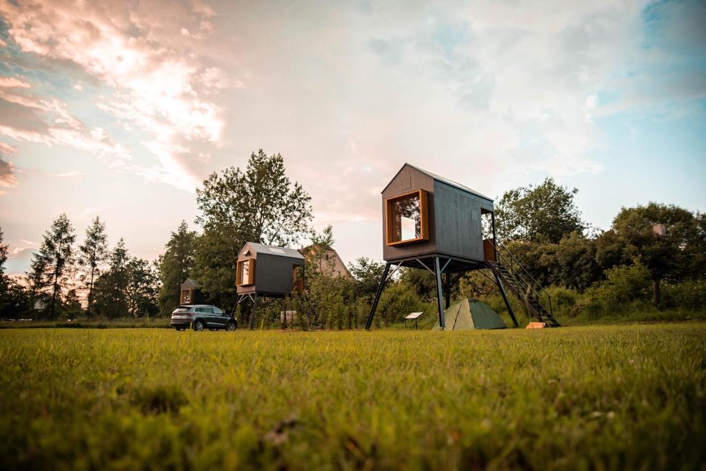Ein Baumhaus auf einem Feld mit einem Truck. in der Unterkunft Posedy Panský dvůr Telč in Telč