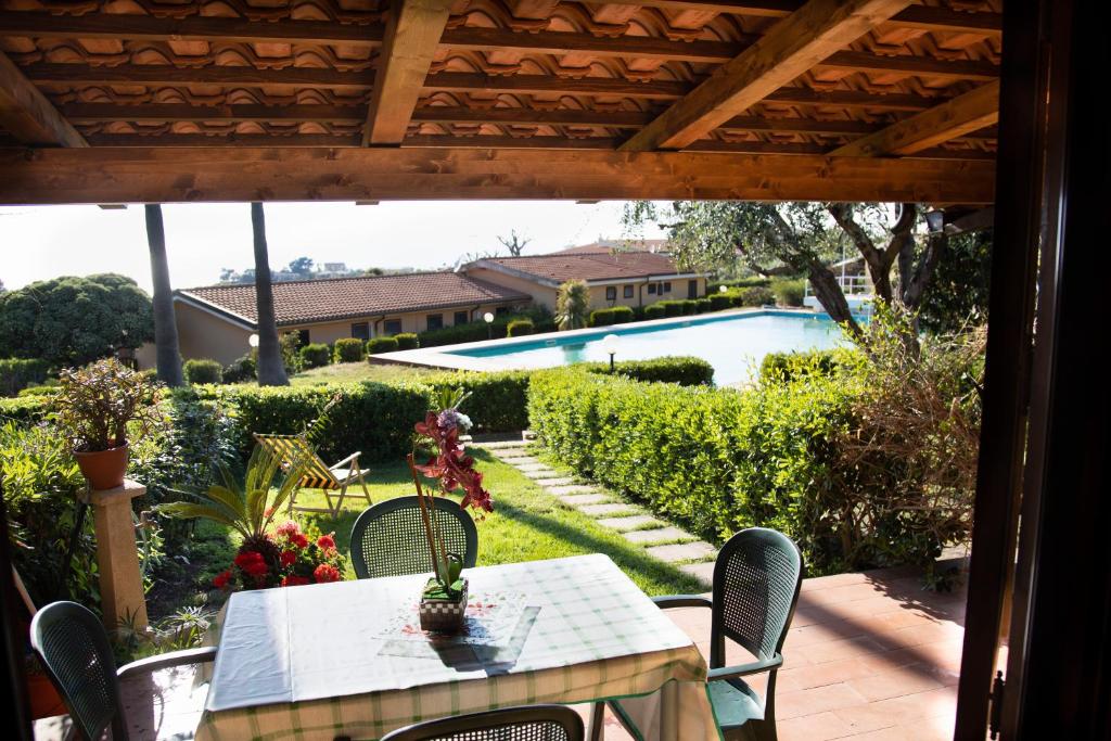 a patio with a table and chairs and a pool at Alloggio incantevole con piscina in Ricadi