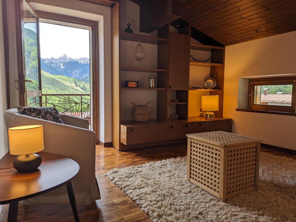 a living room with a couch and a table and a window at Appartement Il Gallo in Forno di Zoldo