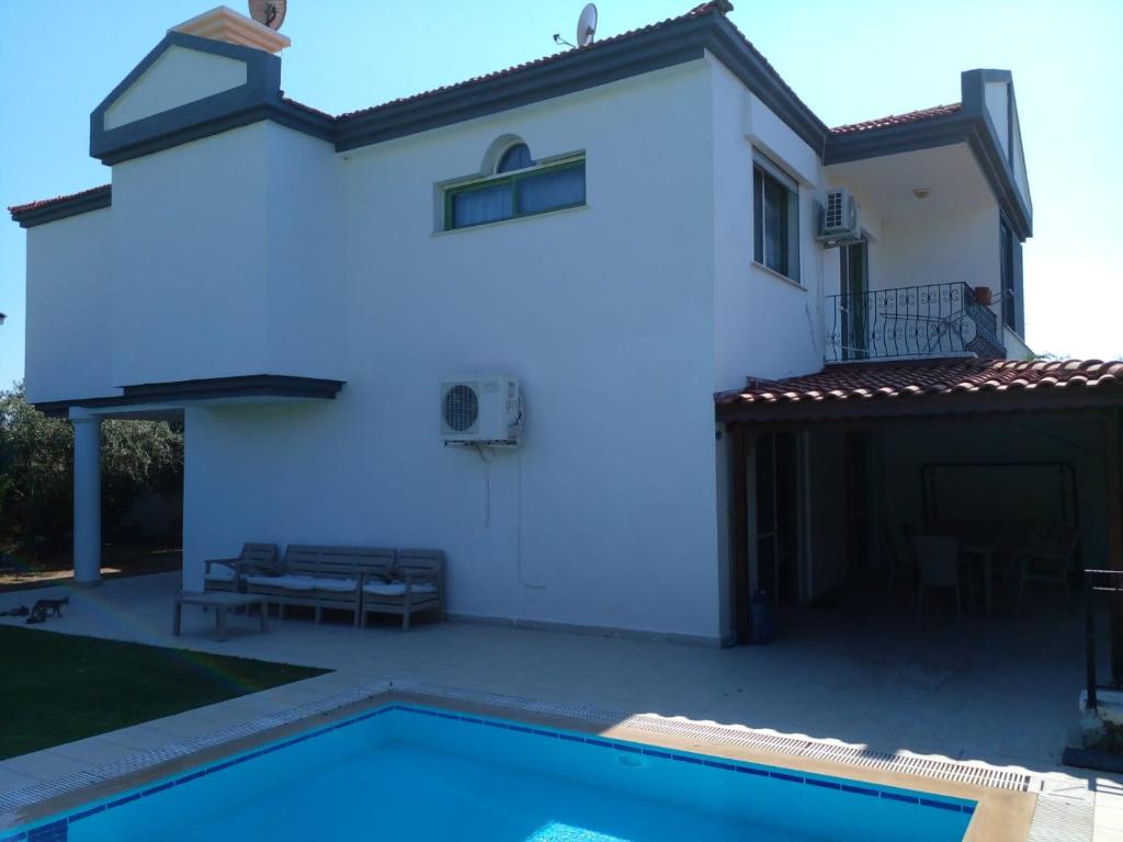 ein weißes Haus mit einem Pool davor in der Unterkunft Luxury villa 3 bedrooms swimming pool in Cesme