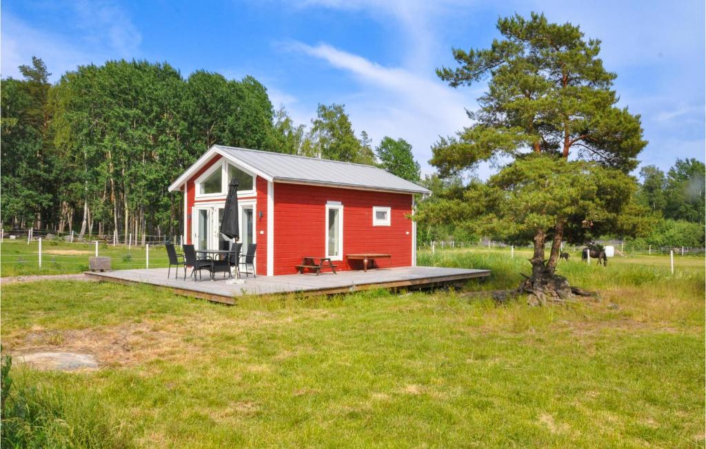 uma pequena casa vermelha com um deque num campo em Nice Home In Hammar With Kitchen em Gunnarskär