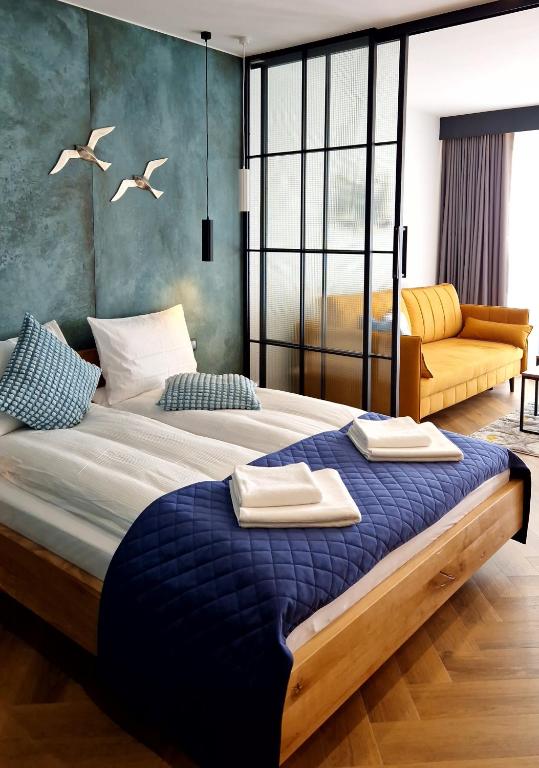a bedroom with a large bed with two towels on it at Lake View Mielno in Mielno