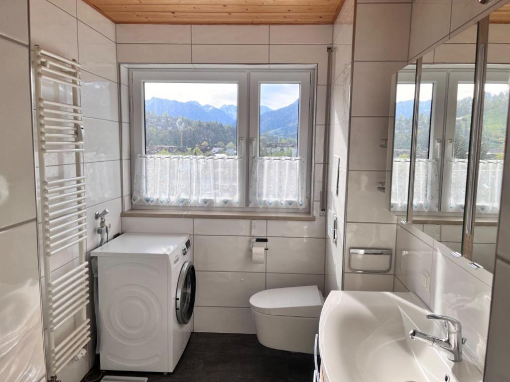 a bathroom with a sink and a toilet and a window at Großzügige Wohnung, Bergblick, Vintage in Sonthofen