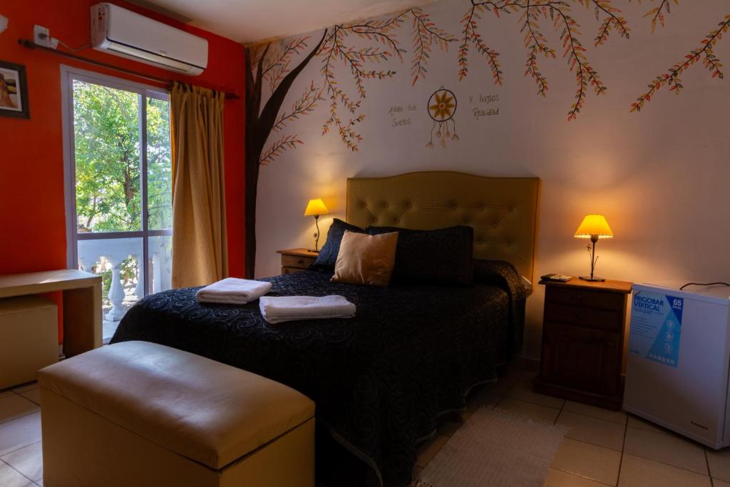 a bedroom with a bed and a tree on the wall at Hotel San Marcos in San Marcos Sierras