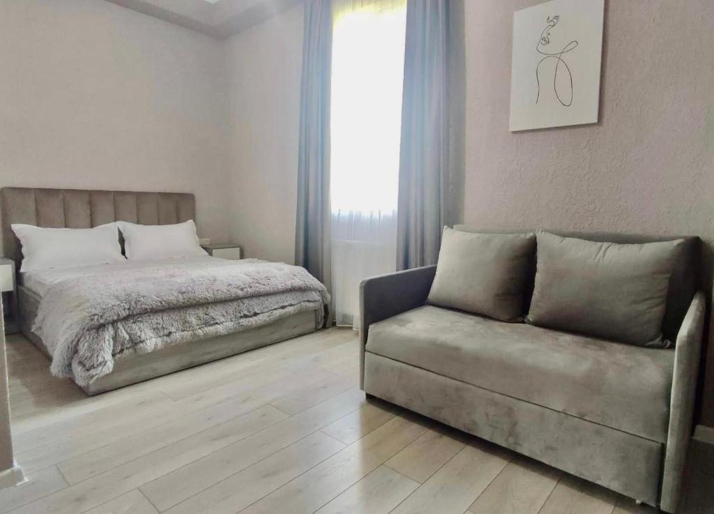 - une chambre avec un lit, un canapé et une fenêtre dans l'établissement Guest House NIMA, à Koutaïssi