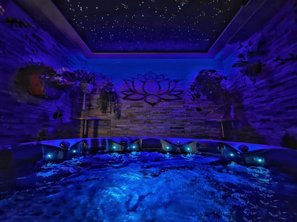 uma banheira de hidromassagem num quarto com um tecto roxo em Hambrook Guest Suites and Private ESPA Spa em Canterbury