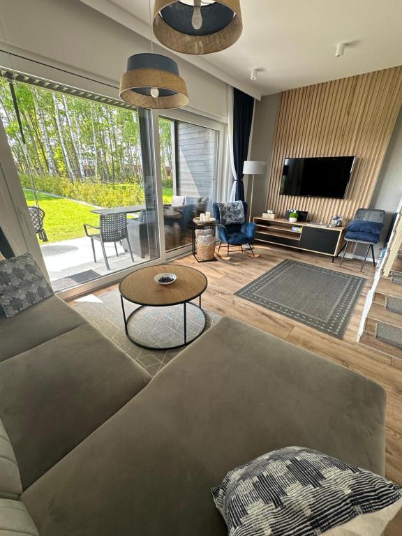 a living room with a couch and a tv at Norda Resort in Dębki