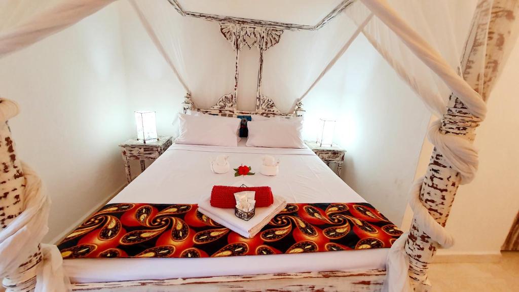 um quarto com uma cama com uma colcha com duas amarras em Lalasalama B&B em Watamu