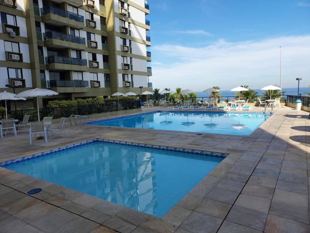 una piscina frente a un edificio en BARRA BELLA PRAIA RESIDENCE - Internet 350mb -TV -AR - Vista mar - Piscina climatizada- HomeOficce, en Río de Janeiro