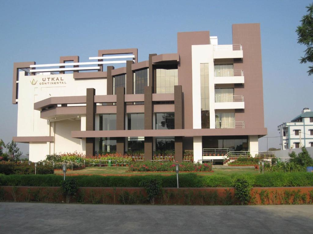 a building with a lot of flowers in front of it at Pipul Utkal Continental in Jhārsuguda