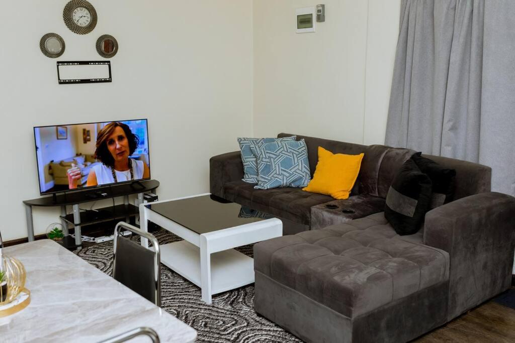a living room with a couch and a tv at Kunyumba Luxury Homes in Lusaka