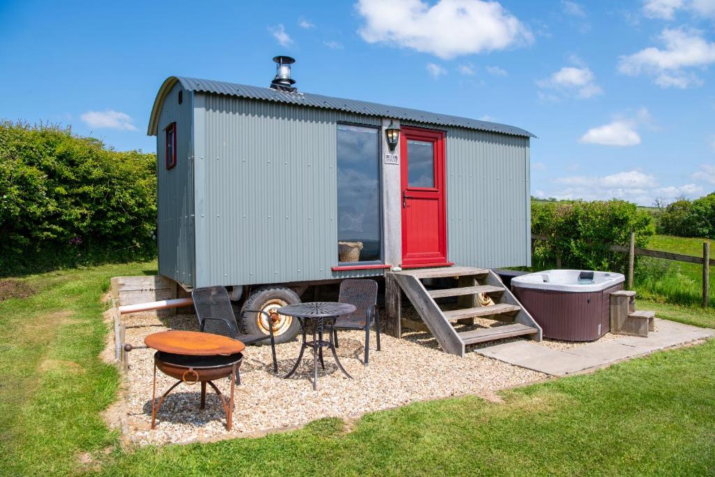 a tiny house with a table and a table at The Big Cwtch Shepherd's Hut in Kidwelly