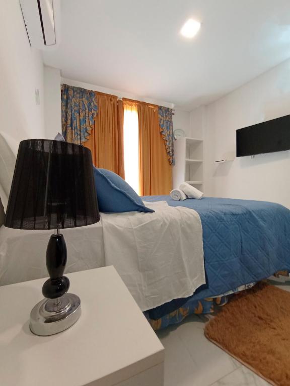 a bedroom with a bed and a lamp on a table at Hermoso Monoambriente ZV308, Edificio Zetta Village Airport in Asuncion