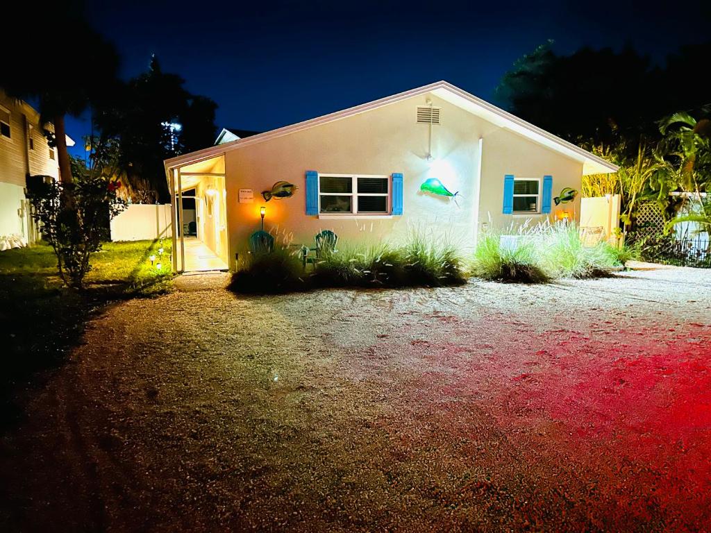 una casa bianca con persiane blu e piante di fronte ad essa di Beach Villa A a Clearwater Beach