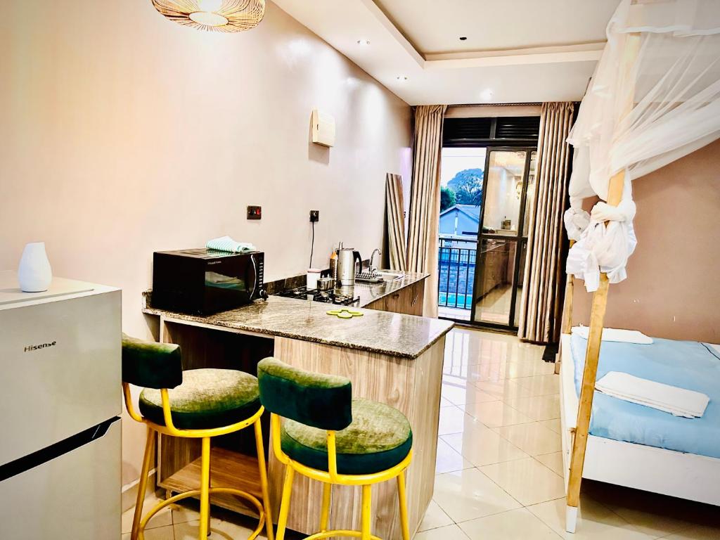 uma cozinha com cadeiras amarelas e verdes num quarto em Trendy apartments em Entebbe
