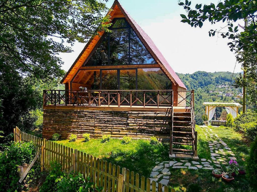 een kleine hut met een rieten dak op een heuvel bij bungalov in Rize