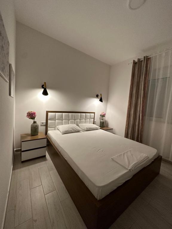 a bedroom with a large bed with white sheets at Long Beach Apartment in Ulcinj