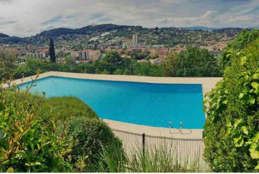 a large blue pool with two people standing in front of it at Charmant studio pour 3 personnes in Vallauris
