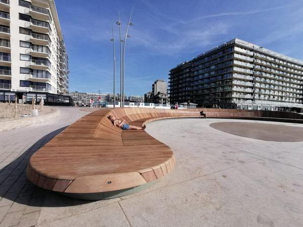 un banc en bois dans un parc d'une ville dans l'établissement Westend Palace, à Middelkerke