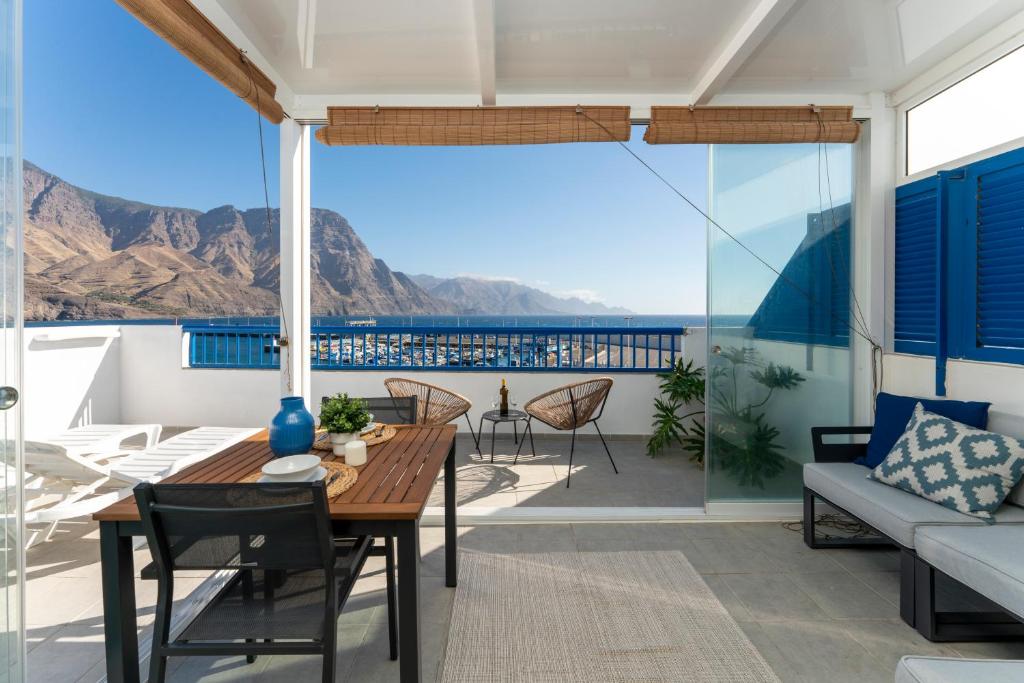 d'un balcon avec une table et des chaises et une vue sur l'océan. dans l'établissement Agaete White&Blue Rooftop, à Agaete