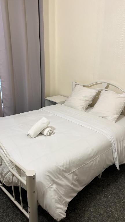 a large white bed with a phone on it at L’ESPERANCE in Versailles