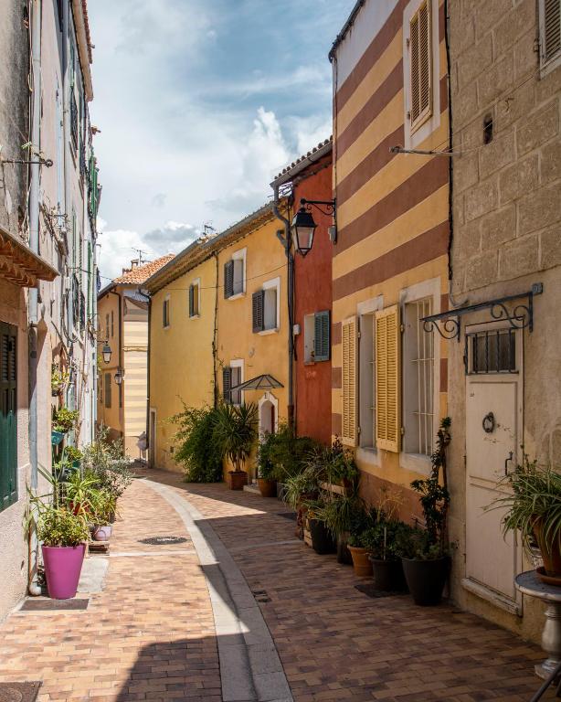 an alley in an old town with potted plants at Appartement le Quai du Port Cassis parking clim in Cassis