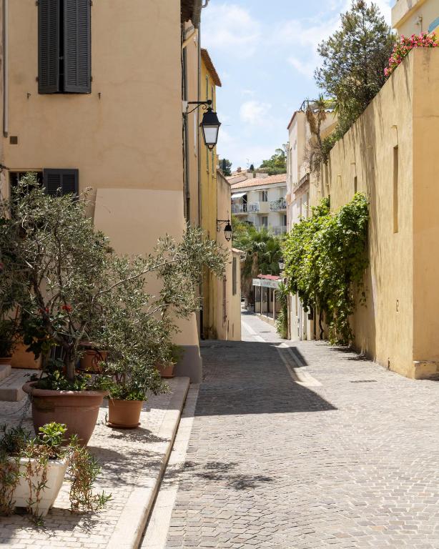 an alley in an old town with potted plants at Appartement le Quai du Port Cassis parking clim in Cassis