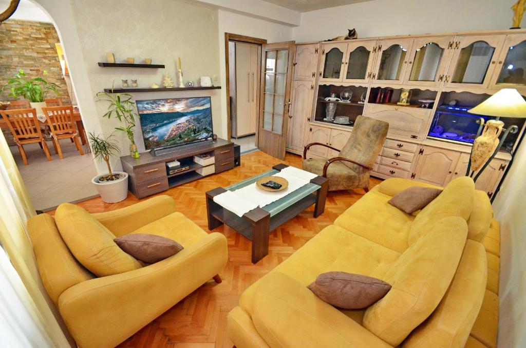 een woonkamer met 2 banken en een tv bij Apartment OAZA in Kotor