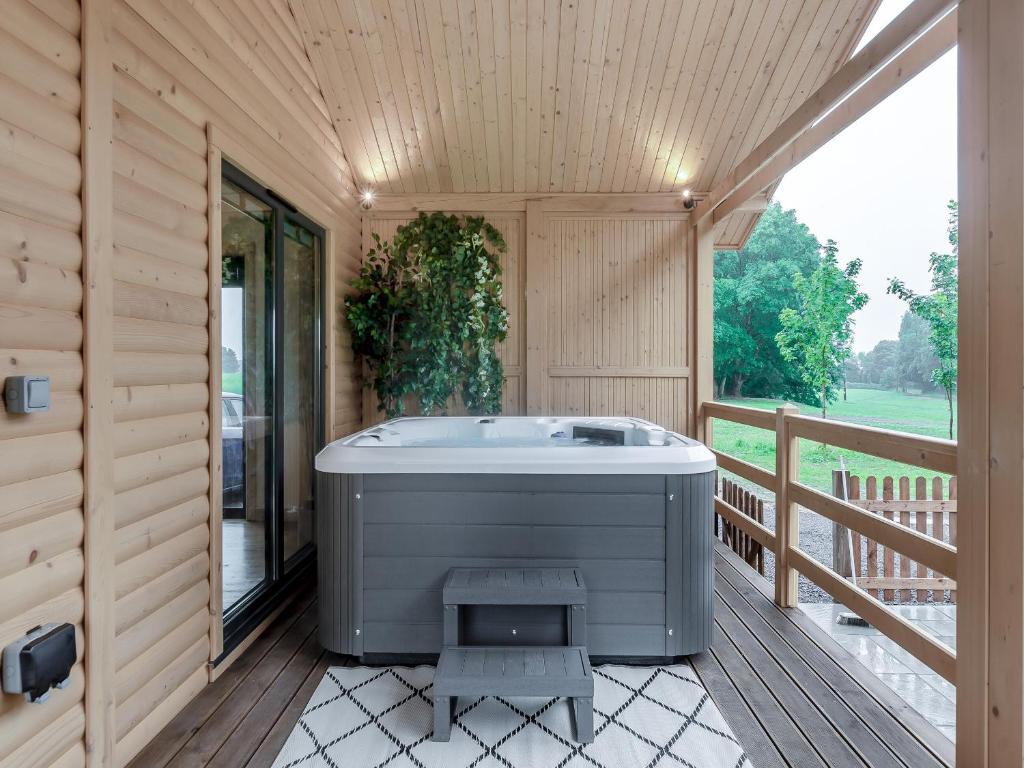 a jacuzzi tub on the deck of a house at Alpaca Lodge in Barkston