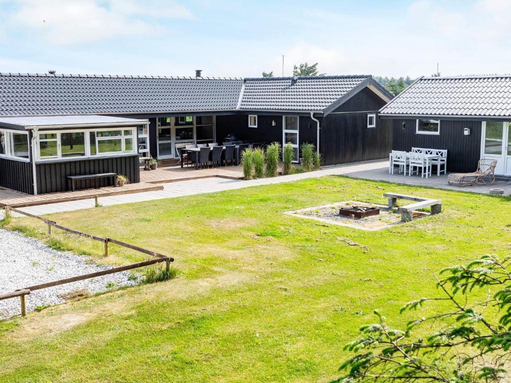 un cortile di una casa con un prato di 12 person holiday home in L kken a Løkken