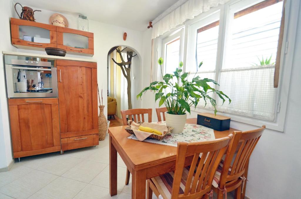 une cuisine et une salle à manger avec une table et des chaises en bois dans l'établissement Apartment OAZA, à Kotor