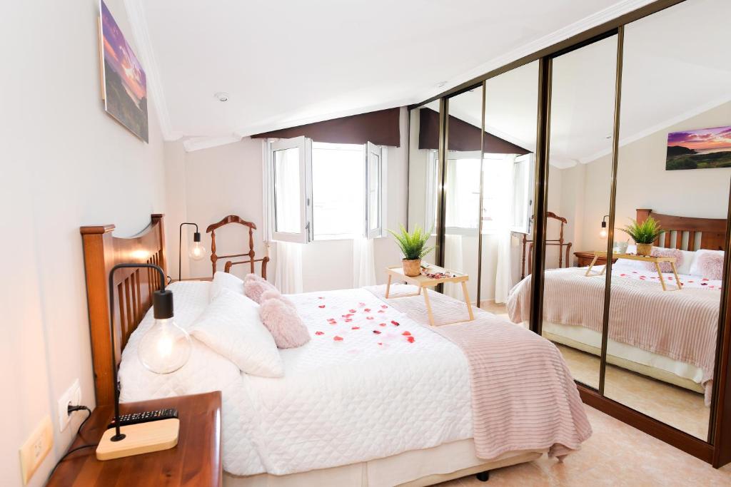 1 dormitorio con 2 camas y un espejo grande en VelayLi - Apartamento en el centro de Finisterre, en Finisterre